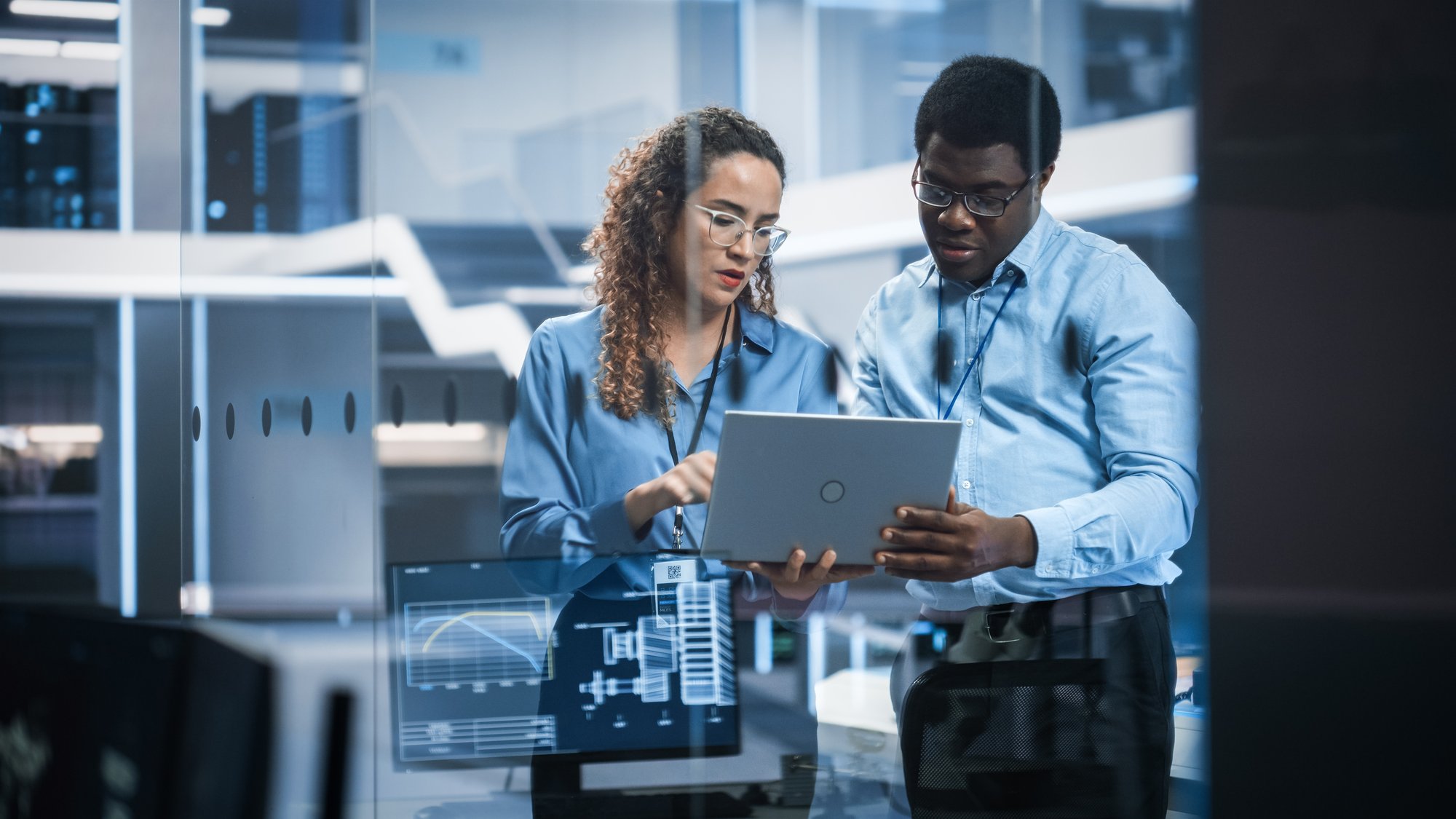 coworkers looking at laptop in tech facility